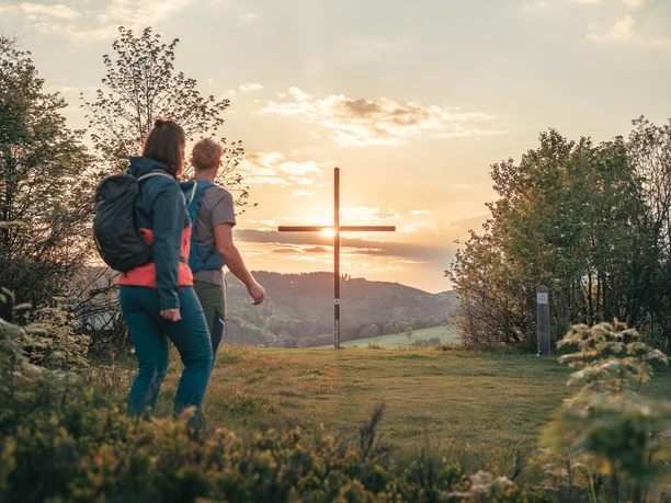 Wanderpaar am Gipfelkreuz auf dem Orenberg Wanderpaar am Gipfelkreuz auf dem Orenberg
