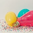 Karnevalsparty Bunte, mit Konfetti übersäte Luftballons auf hellem Hintergrund, die eine fröhliche Feier andeuten.