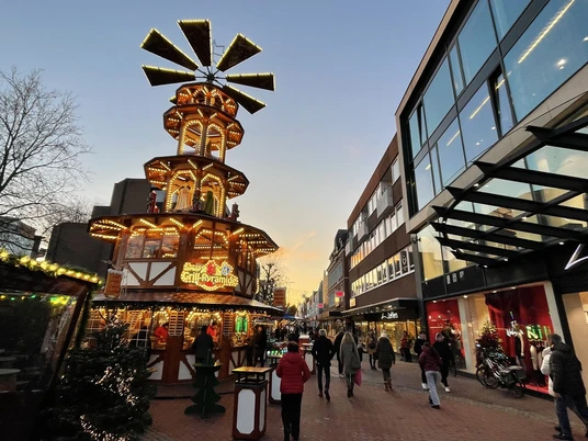 Weihnachtsmarkt Leer Pyramide Beleuchtete Weihnachtspyramide mit Figuren und Besuchern in der Fußgängerzone von LeerThe picture shows the pyramid on the Mühlenplatz in LerrDe foto toont de piramide op de Mühlenplatz in LerrBilledet viser pyramiden på Mühlenplatz i Lerr.