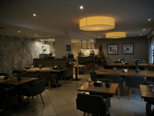 Gemütlich eingerichtetes Restaurant mit modernem Ambiente, gedimmter Beleuchtung und stilvoller Dekoration.