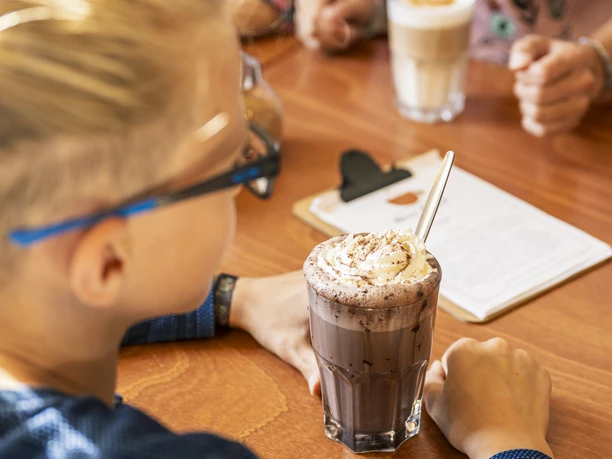 "Heiße Schokolade" im Café Herr Biber im Schloss Bleckede Junge trinkt eine große heiße Schokolade im Café Herr Biber im Schloss Bleckede