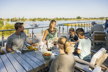 Familie genießt beim Essen auf der oberen Terrasse den Blick auf den Hafen von Bleckede