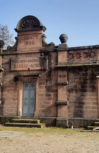 Großes Gebäude aus Buntsandstein aus dem 19. Jahrhundert, mit Aufschrift Wasserversorgung Illenau-Achern zusätzlich gibt es 3 stählerne blaugefärbte Türen am Gebäude, dahinter verbirgt sich die Wasserversorgung.
