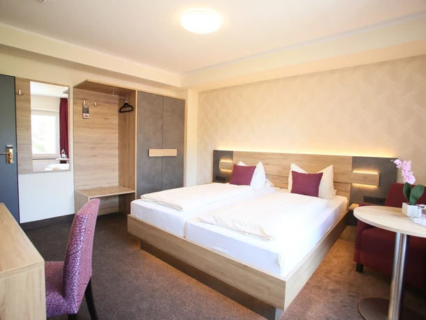 Hotel Münchner Hof-Herford (6).JPG Helles Hotelzimmer mit zwei Einzelbetten, künstlerischer Beleuchtung und modernen Möbeln.