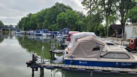 Hafen Getmold Boote am Hafen Getmold, umgeben von grünen Bäumen und ruhigem Wasser, Bootssteg linksseitig belegt.