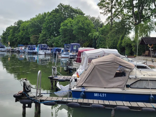 Hafen Getmold Boote am Hafen Getmold, umgeben von grünen Bäumen und ruhigem Wasser, Bootssteg linksseitig belegt.