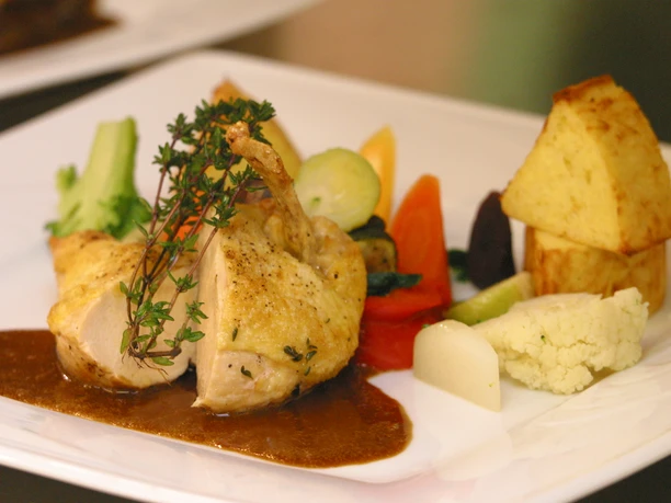 Restaurant Aureus im Hotel Vivendi-Herford (5).JPG Ein kunstvoll angerichtetes Tellergericht mit Huhn, frischem Gemüse und einer dunklen Sauce.