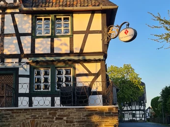 Hotel von Landsberg Fachwerkhaus in ruhiger Straße im Sonnenuntergang, mit dekorativem Eisenbalkon und Laterne.