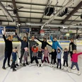 Bild Familienzentrum Luftikus 5.jpg Eine Gruppe von Erwachsenen und Kindern steht fröhlich auf einer Eislaufbahn, bereit zum Eislaufen.