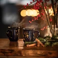 Zwei Tassen mit Glühwein stehen auf einem Tisch