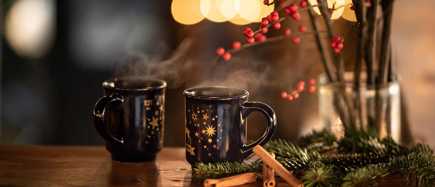 Zwei Tassen mit Glühwein stehen auf einem Tisch Zwei Tassen mit Glühwein stehen auf einem Tisch