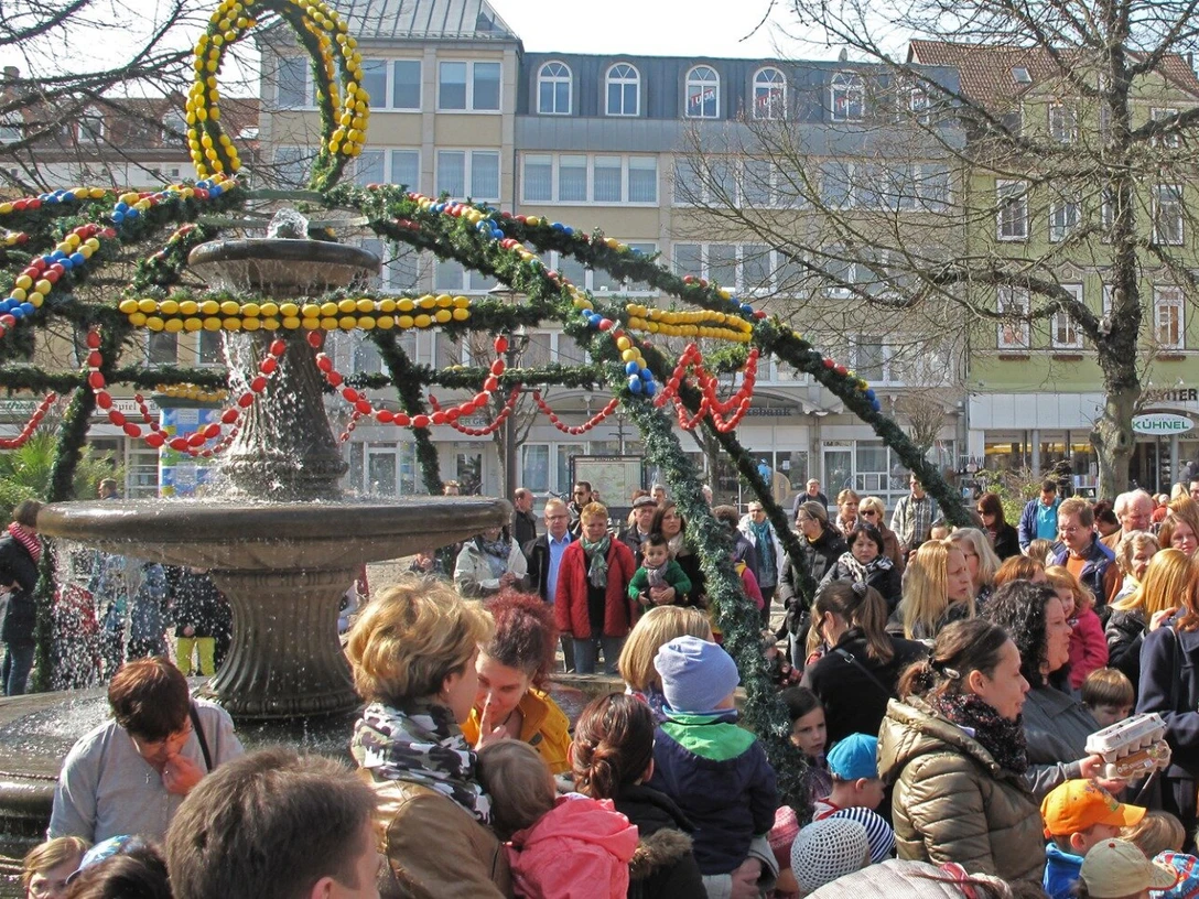Fröhliches Familienfest: Der Peiner Osterbrunnen erstrahlt in buntem Schmuck! Osterbrunnen auf dem Marktplatz in Peine mit FamilienEaster fountain on the market square in Peine with familiesPåskefontæne på markedspladsen i Peine med familierPaasfontein op het marktplein in Peine met families