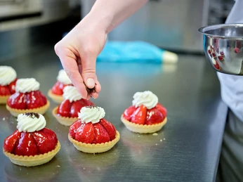 Die frischen Erdbeertörtli werden verziert