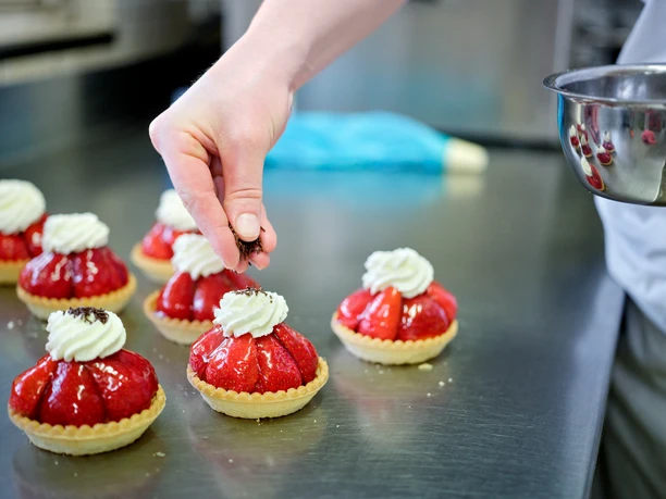 Die frischen Erdbeertörtli werden verziert