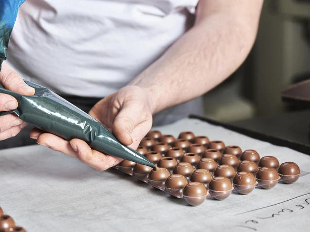 Pralinenhüllen, präzise gefüllt mit verschiedenen edlen Füllungen