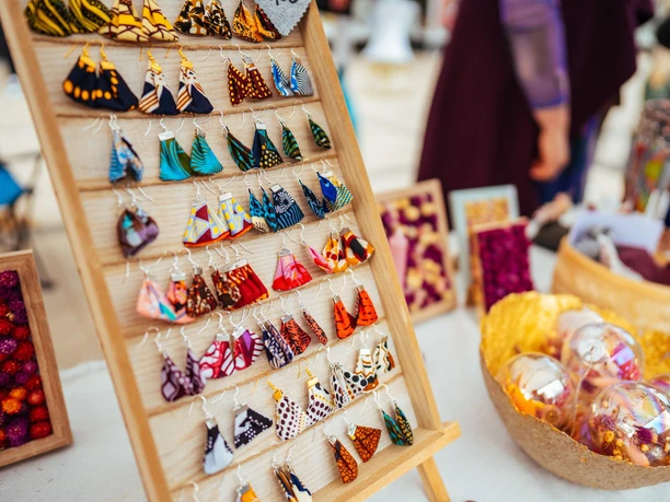 Ein Kreativmarktstand auf dem Monheimer Frühlingsfest Verschiedene handgefertigte bunte Schmuckanhänger und Verzierungen auf einem Kreativmarktstand.