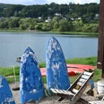 Stühle und ehemalige Surfbretter im Vordergrund und Edersee im Hintergrunf
