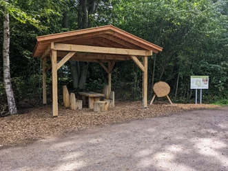 PXL_20220917_102030668.MP-min.jpg Holzpavillon mit Sitzgruppe aus Baumstämmen am Waldrand des Waldentdeckerpfads Bramsche-Polle.