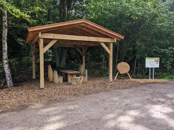 PXL_20220917_102030668.MP-min.jpg Holzpavillon mit Sitzgruppe aus Baumstämmen am Waldrand des Waldentdeckerpfads Bramsche-Polle.
