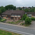 Steinernes Rathaus der Gemeinde Borchen mit gepflegter Gartenanlage, an einer ruhigeren Straße gelegen.