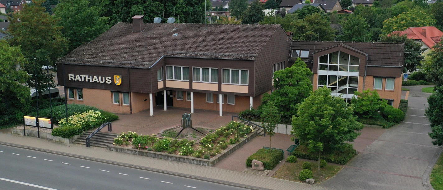 Steinernes Rathaus der Gemeinde Borchen mit gepflegter Gartenanlage, an einer ruhigeren Straße gelegen.