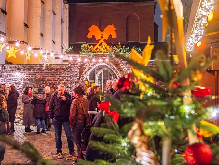 Christmas market with festive lighting Der Weihnachtsmarkt bietet in einem kleinen Innenhof mit festlich beleuchteter Kulisse weihnachtliche Atmosphäre.The Christmas market offers a Christmassy atmosphere in a small courtyard with a festively illuminated backdrop.