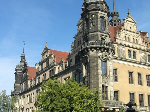 Residenzschloss.jpg Historisches Schloss mit reich verzierter Fassade und Türmen an einem sonnigen Tag in der Stadt.