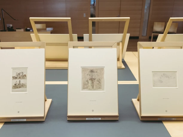 Caspar David Friedrich - Arbeiten des Künstlers im Kupferstich-Kabinett.jpg Drei gerahmte Zeichnungen von Caspar David Friedrich stehen auf Holzaufstellern in einem Museum.