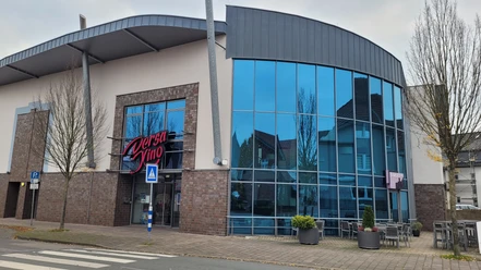 Dersa Kino Rahden mit moderner Glasfassade, Eingangsbereich und Außenbestuhlung vor dem Gebäude.