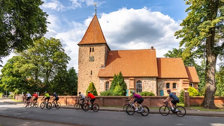 Rennradgruppe vor der St. Bartholomäus-Kirche in Kirchwalsede Rennradgruppe vor der St. Bartholomäus-Kirche in Kirchwalsede