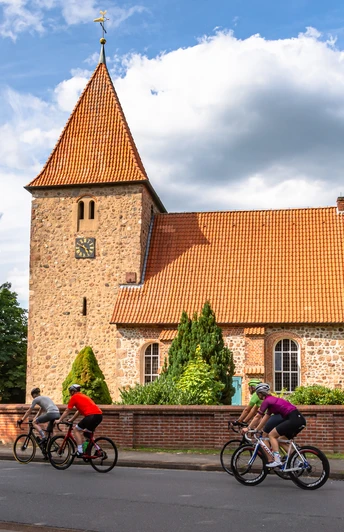 Rennradgruppe vor der St. Bartholomäus-Kirche in Kirchwalsede Rennradgruppe vor der St. Bartholomäus-Kirche in Kirchwalsede