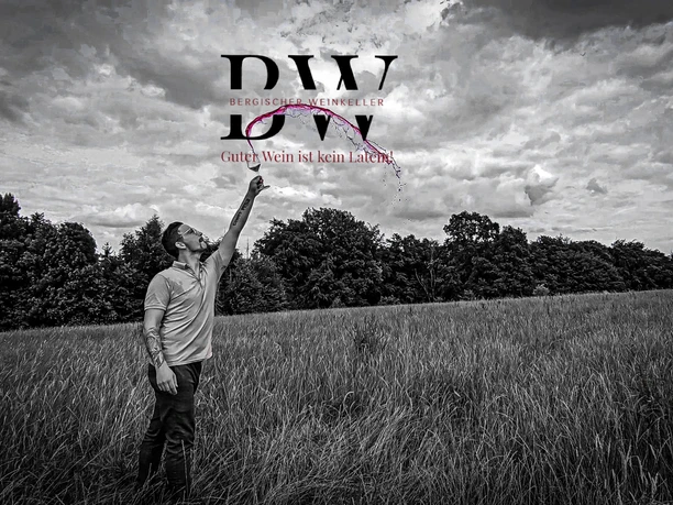 Bergischer Weinkeller Mann auf Feld in schwarz-weißem Foto, zeigt in dramatischen Himmel, Atmosphäre von Freiheit.
