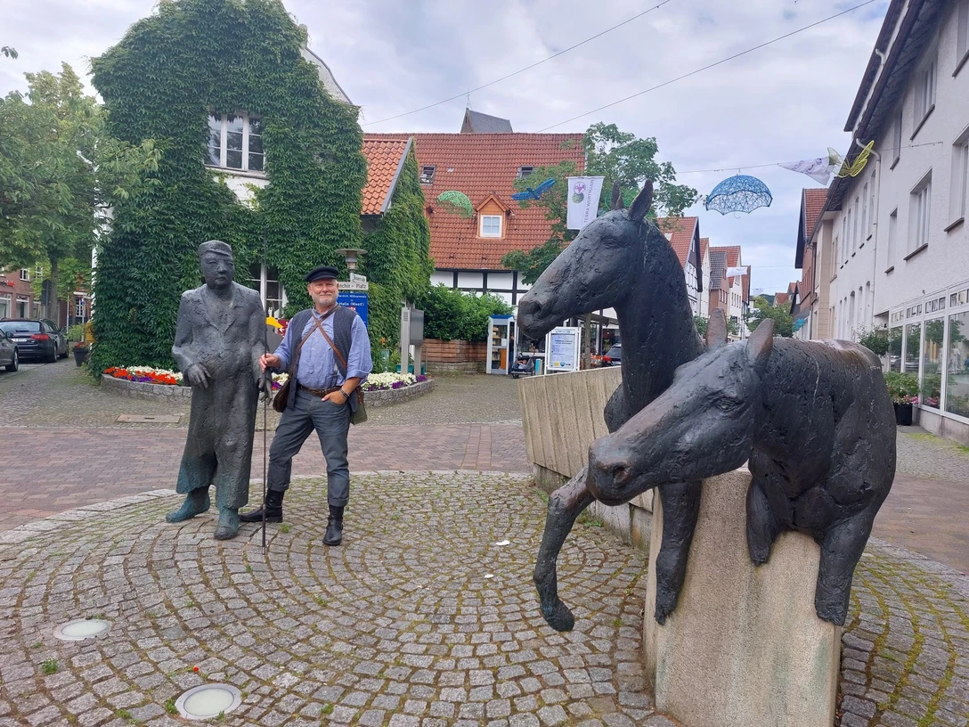 haller_willem.jpg Zwei Bronzeskulpturen in einer gepflasterten Straße zeigen Pferde und Männer bei einer Plauderei.