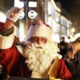 Nikolaus.JPG Nikolaus in rotem Mantel mit weißem Bart winkt in stimmungsvoll beleuchteter Einkaufsstraße.