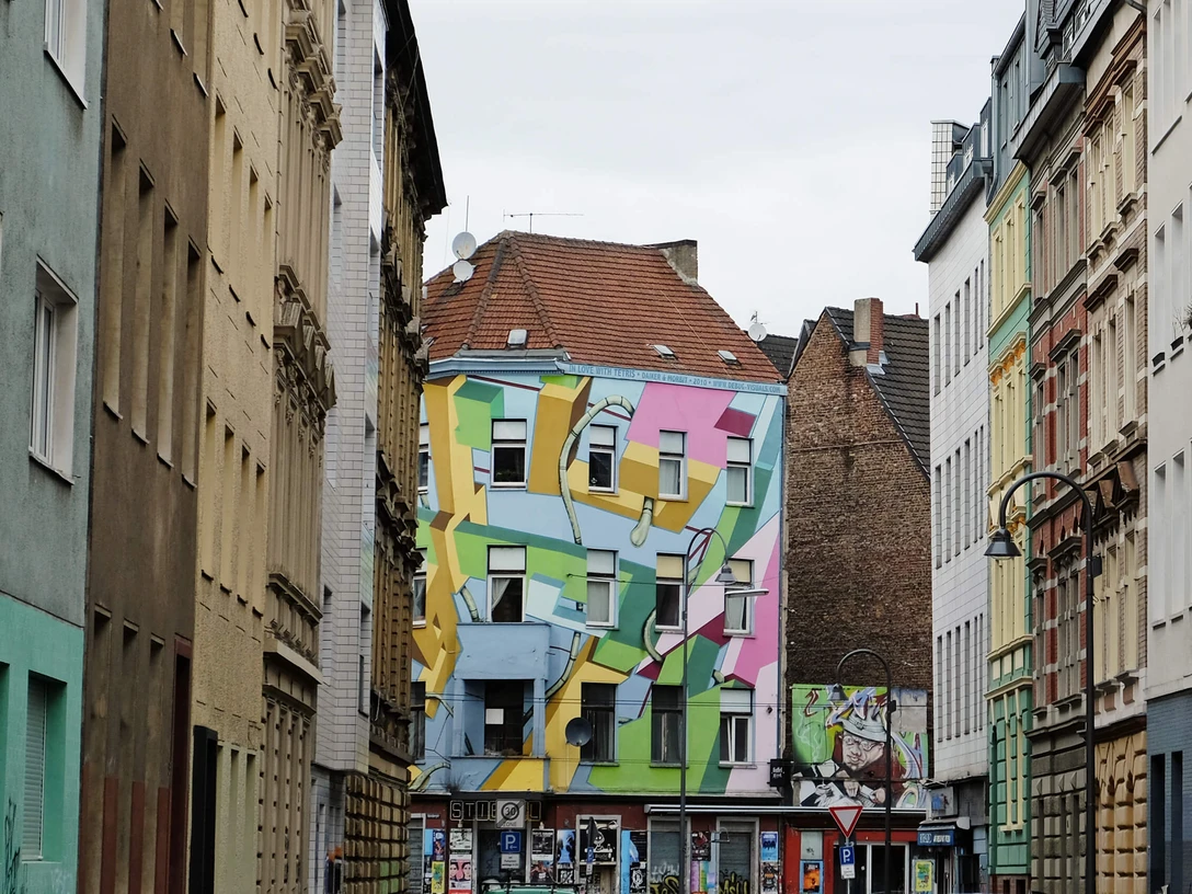 Mural Bunt bemaltes Gebäude an der Zülpicher Straße in Köln, mit geometrischen Formen in Pastellfarben auf der Fassade.Brightly painted building on Zülpicher Strasse in Cologne, with geometric shapes in pastel colors on the façade.