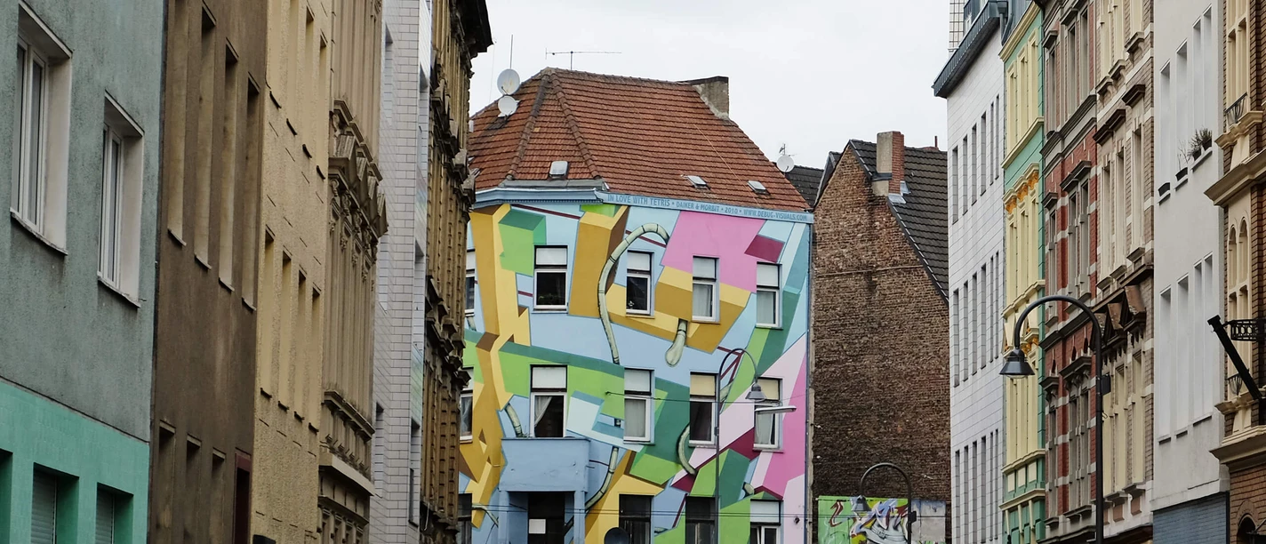 Mural Brightly painted building on Zülpicher Strasse in Cologne, with geometric shapes in pastel colors on the façade.