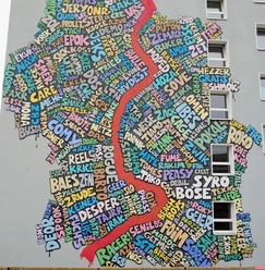 Mural Eine bunte Wandgemälde-Collage in Köln: Wörter als Kunst formen eine regionale Karte.