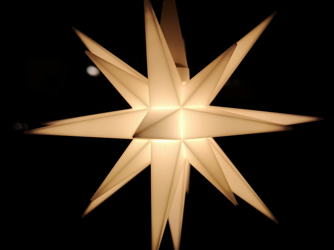 ein leuchtender Weihnachtsstern aus Pappe im Dunkelna glowing cardboard poinsettia in the darken lysende julestjerne af pap i mørketeen gloeiende kartonnen kerstster in het donker