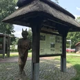 Das Dorf Teufelsmoor Infotafel mit Reetdach und einer Holzskultur eines Teufels