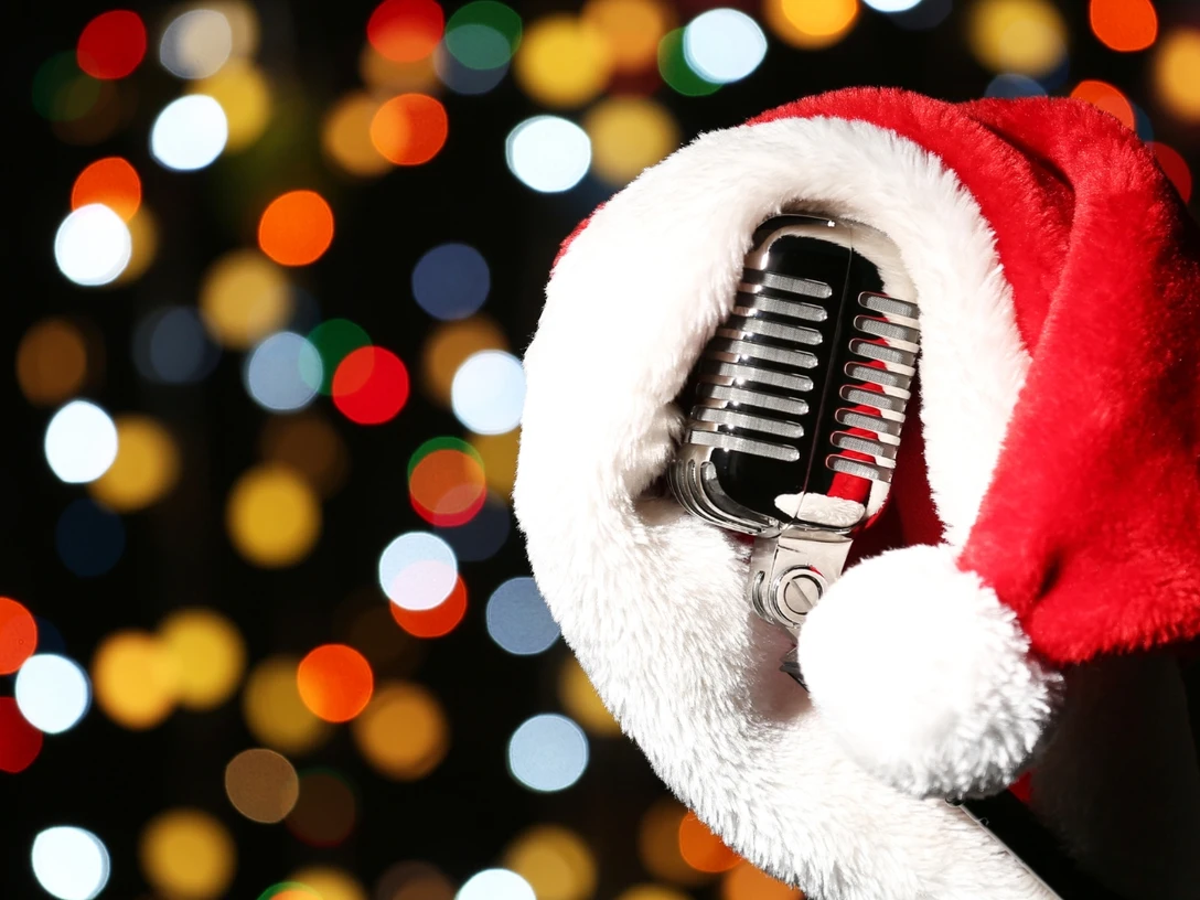 Karaoke Nikolausparty Mikrofon mit Nikolausmütze vor buntem Lichterhintergrund, stimmungsvoll für eine Karaoke-Party.