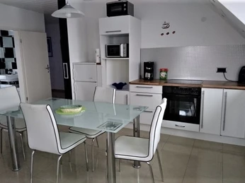 Moderne, helle Küche mit Glastisch und sechs Stühlen, einer kompletten Ausstattung und viel Licht.