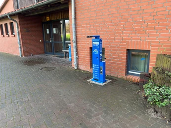 Radstation Hoyerhagen Fahrradservice-Station vor einem roten Backsteingebäude mit Schaufenster und Eingangstür.