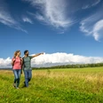 Höxter-Flugplatz Höxter-Holzminden-Teutoburger-Wald-Stadt Höxter-D-Ketz-025.jpg Über Wiesen wanderndes Pärchen mit hoch getürmten Wolken im HintergrundCouple walking across meadows with towering clouds in the background