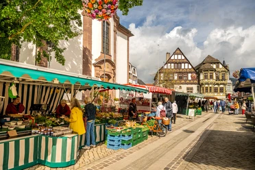 Höxter-Marktstraße-Teutoburger-Wald-Stadt Höxter-D-Ketz-005.jpg Wochenmarkt mit Gemüseständen in der Fußgängerzone mit Einkaufenden und reich verziertem Fachwerkgebäude im Hintergrund