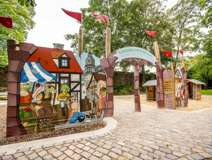 Höxter-Spielplatz Welt des Mittelalters-Teutoburger-Wald-Stadt Höxter-D-Ketz-175.jpg Spielplatzwand mit historischer Marktszene und Gucklöchern Playground wall with historical market scene and peepholes