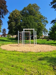1_ParkMitPotential.jpg Geometrisches Klettergerüst in einem weitläufigen Park mit grüner Wiese und hohen Bäumen im Hintergrund.