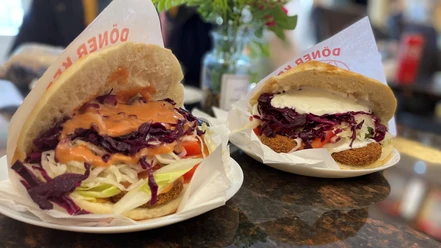 Falaffel_Tasche_CCBYSA_Teutoburger Wald_Stadt_Schloß Holte-Stukenbrock.jpg Zwei gefüllte Falafeltaschen mit frischem Salat und Saucen auf weißen Tellern in einem Restaurant.