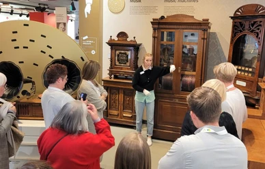 Führung Deutsches Automatenmuseum Eine Gruppe von Menschen lauscht einer Führung durch historische Musikautomaten in einem Museum.
