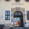 tourist-information-stolpen-(c)-heike-grunow-cc0.jpg Eingang des Alten Amtsgerichts mit Blumen über dem Schild, Plakate vor der Tür und einer Bank daneben; ruhige Atmosphäre.Tourist information StolpenTuristické informace StolpenToeristische informatie StolpenWejście do starego sądu rejonowego z kwiatami nad szyldem, plakatami przed drzwiami i ławką obok; spokojna atmosfera.Ingresso del vecchio tribunale distrettuale con fiori sopra l'insegna, manifesti davanti alla porta e una panchina accanto; atmosfera tranquilla.