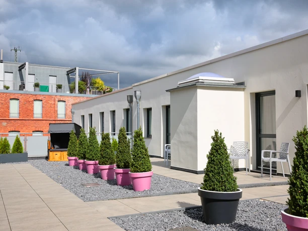 City-Hotel Apart-Go-25-Dachgarten.JPG Dachterrasse mit modernen Sitzgelegenheiten und großen Pflanzkübeln; geeignet für Entspannung im Freien.